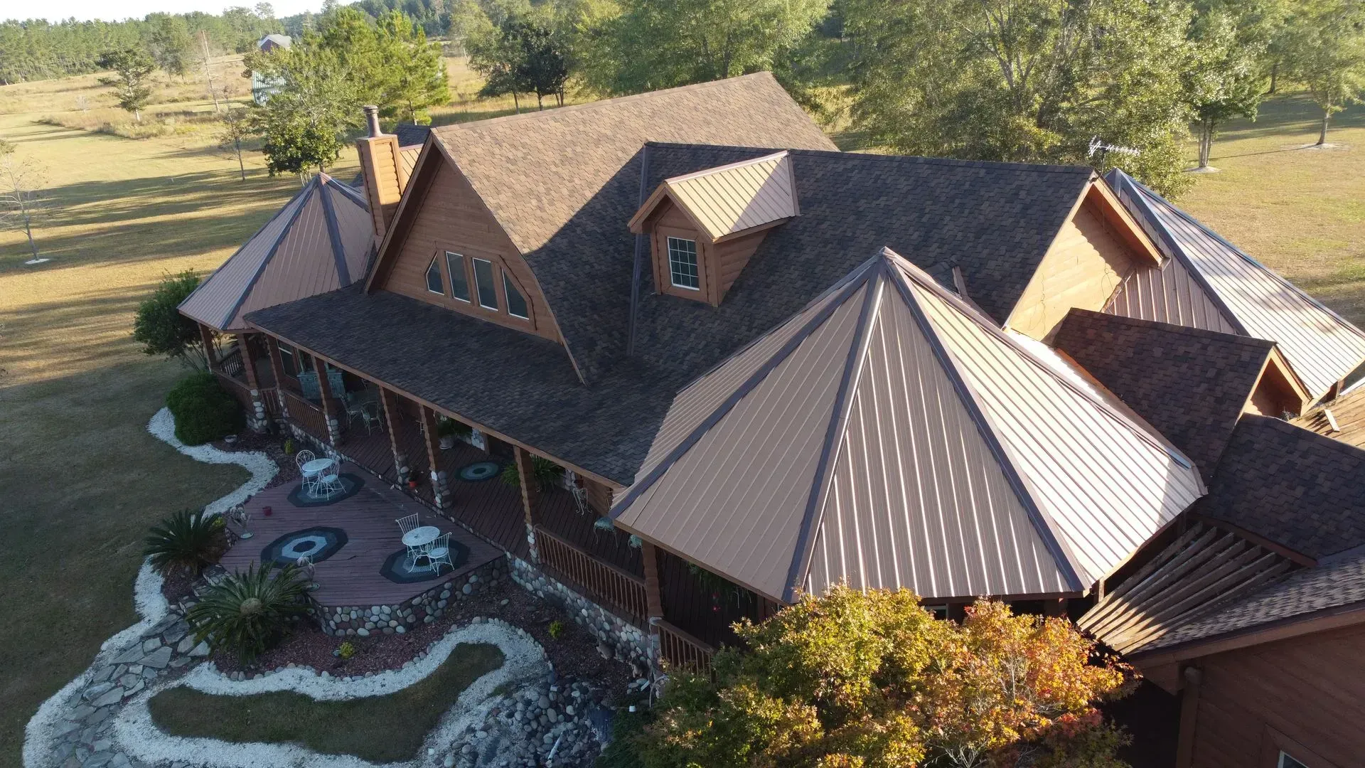 Brown cabin with a metal roof on a grassy field.