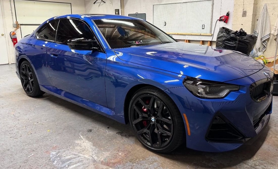 A blue bmw is parked in a garage.