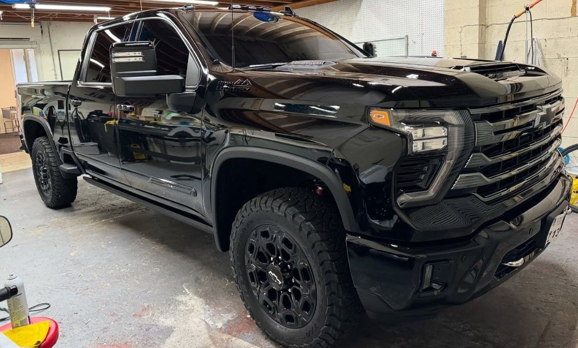 A black truck is parked in a garage.