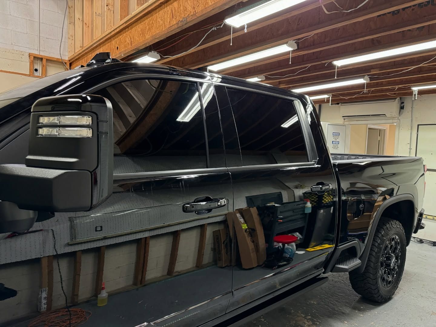 A black truck is parked in a garage.