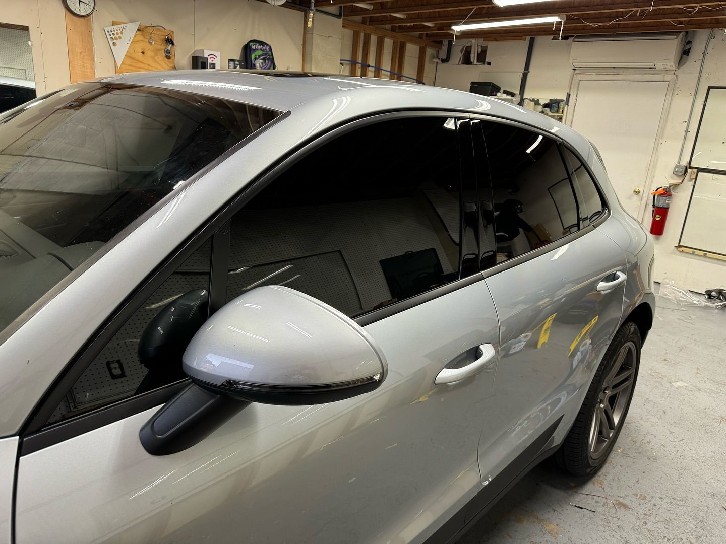 A silver porsche macan turbo is parked in a garage.