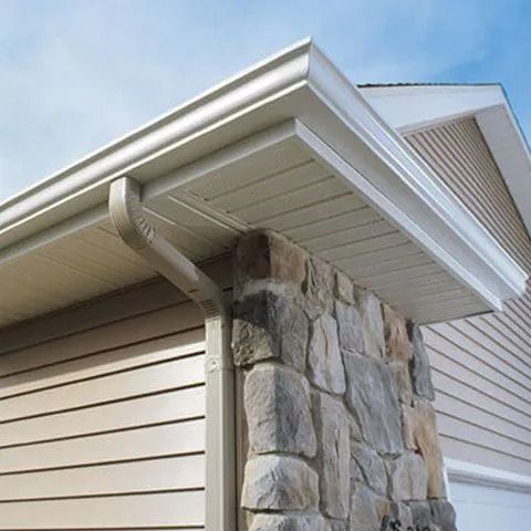 Beige siding and soffit with stone pillar and downspout.