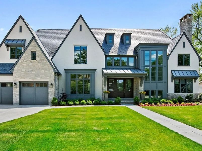 Elegant white house with gray accents, green lawn, and walkway.