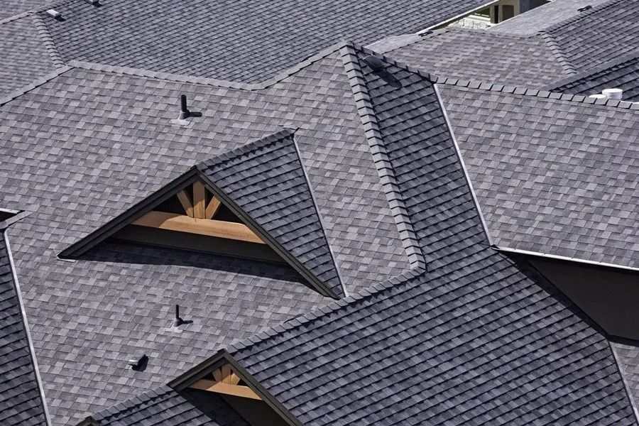 Gray asphalt shingle rooftops with triangular architectural elements and wooden supports.
