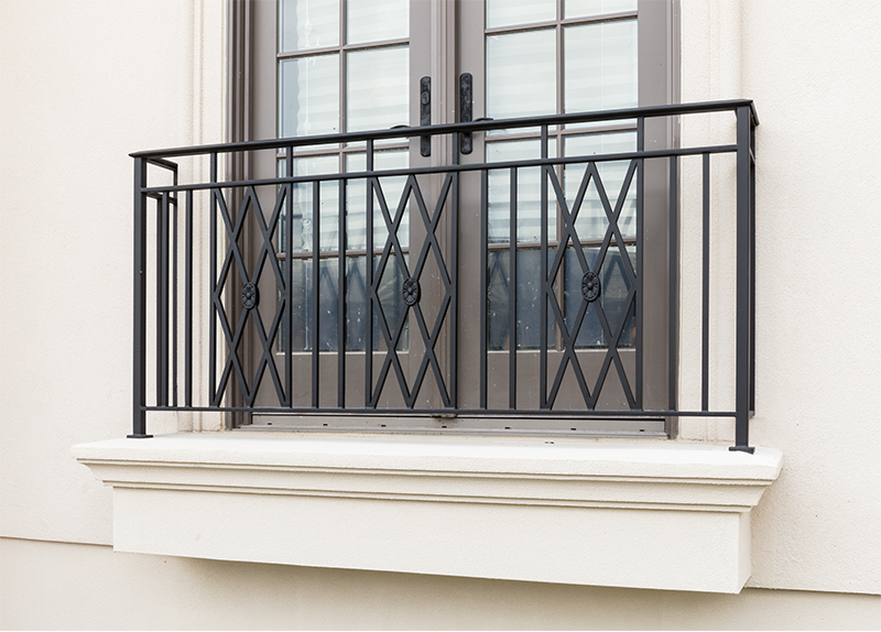 A balcony with a wrought iron railing on the side of a building.