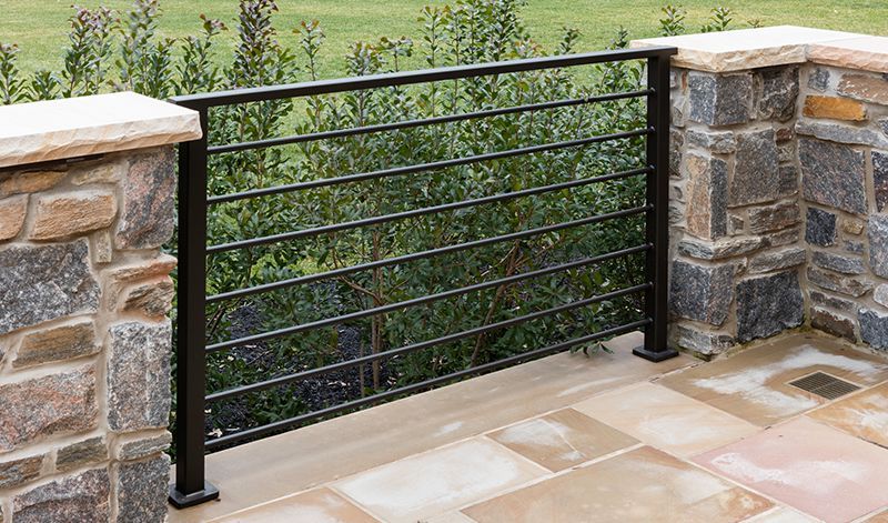 A stone wall with a metal railing on it