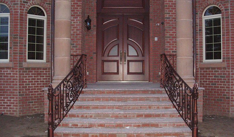 A brick building with stairs leading up to the front door
