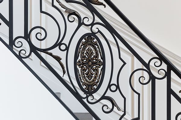 A close up of a wrought iron railing on a staircase