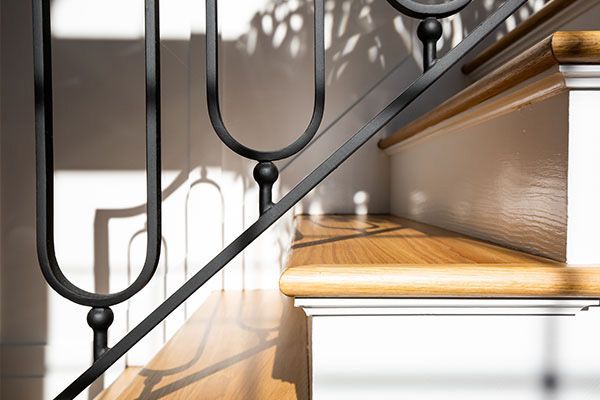 A staircase with a black railing and wooden steps