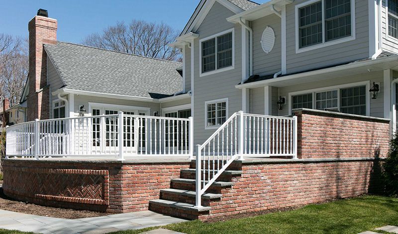A large house with a white deck and railing