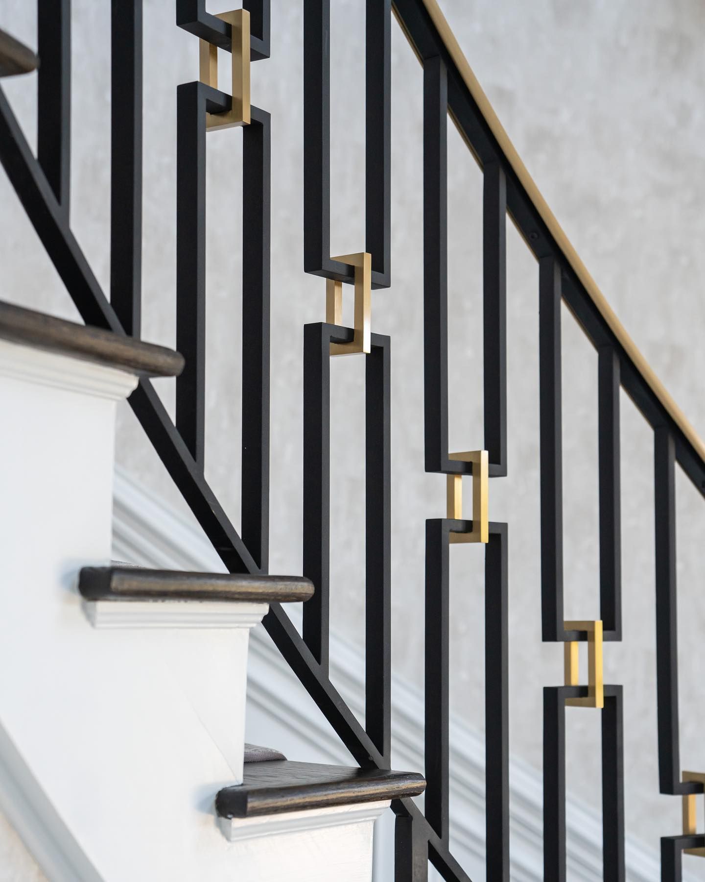 A close up of a black and gold railing on a staircase