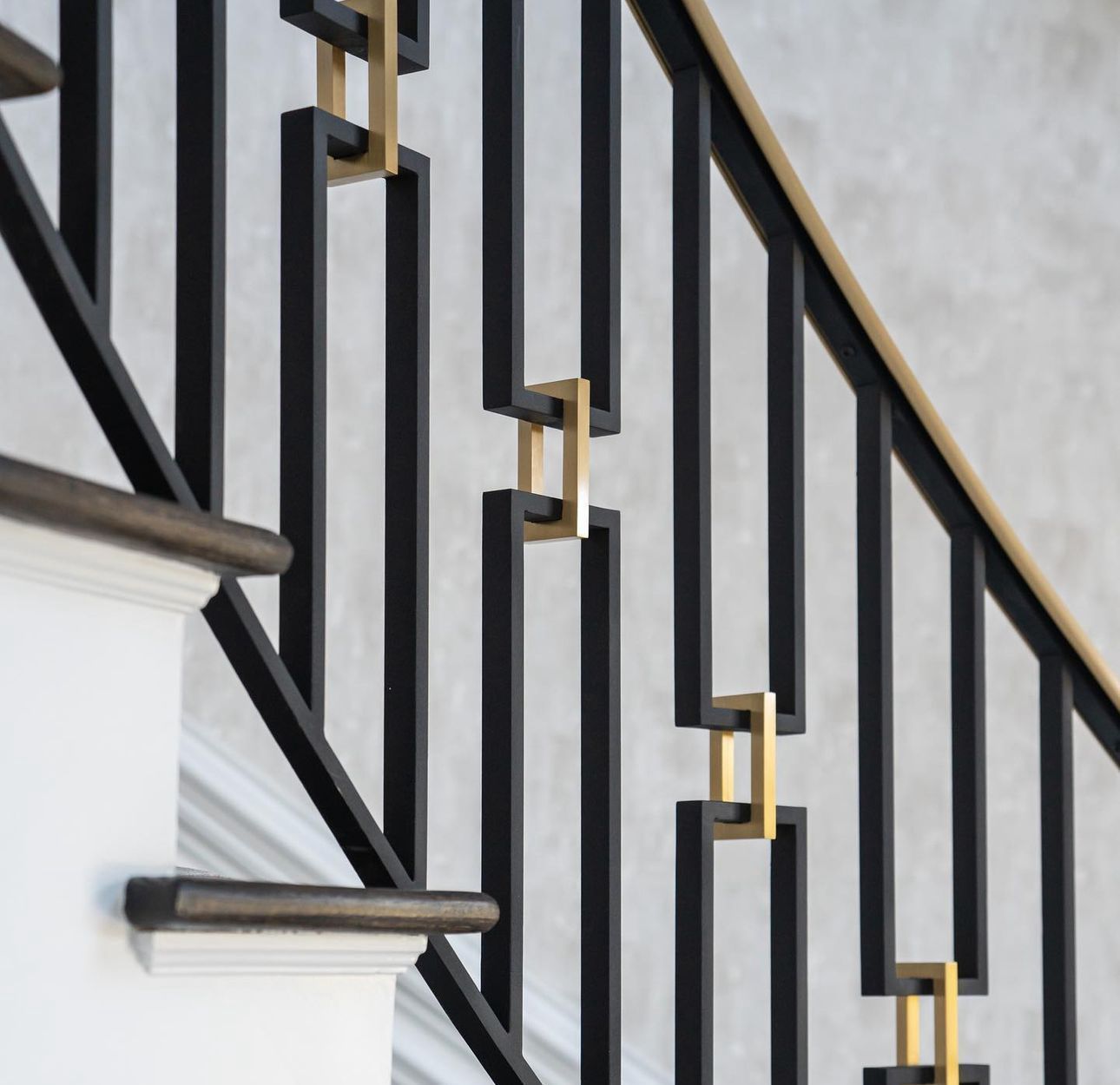 A close up of a black and gold railing on a staircase