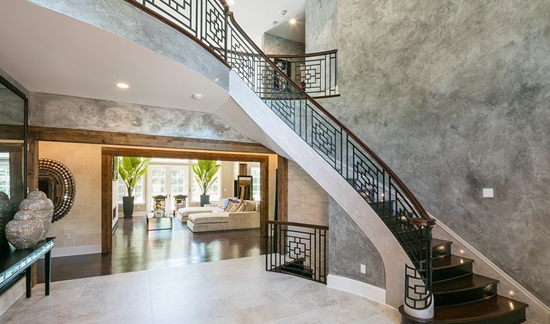 A large staircase in a house with a living room in the background