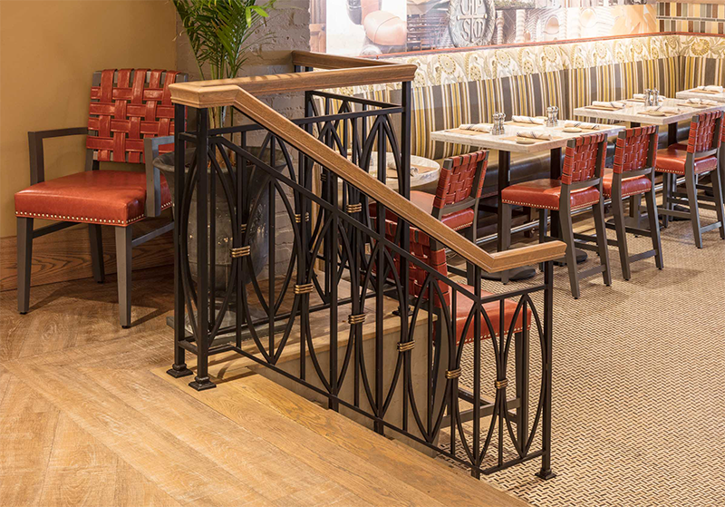 A large lobby with a chandelier hanging from the ceiling and a staircase.