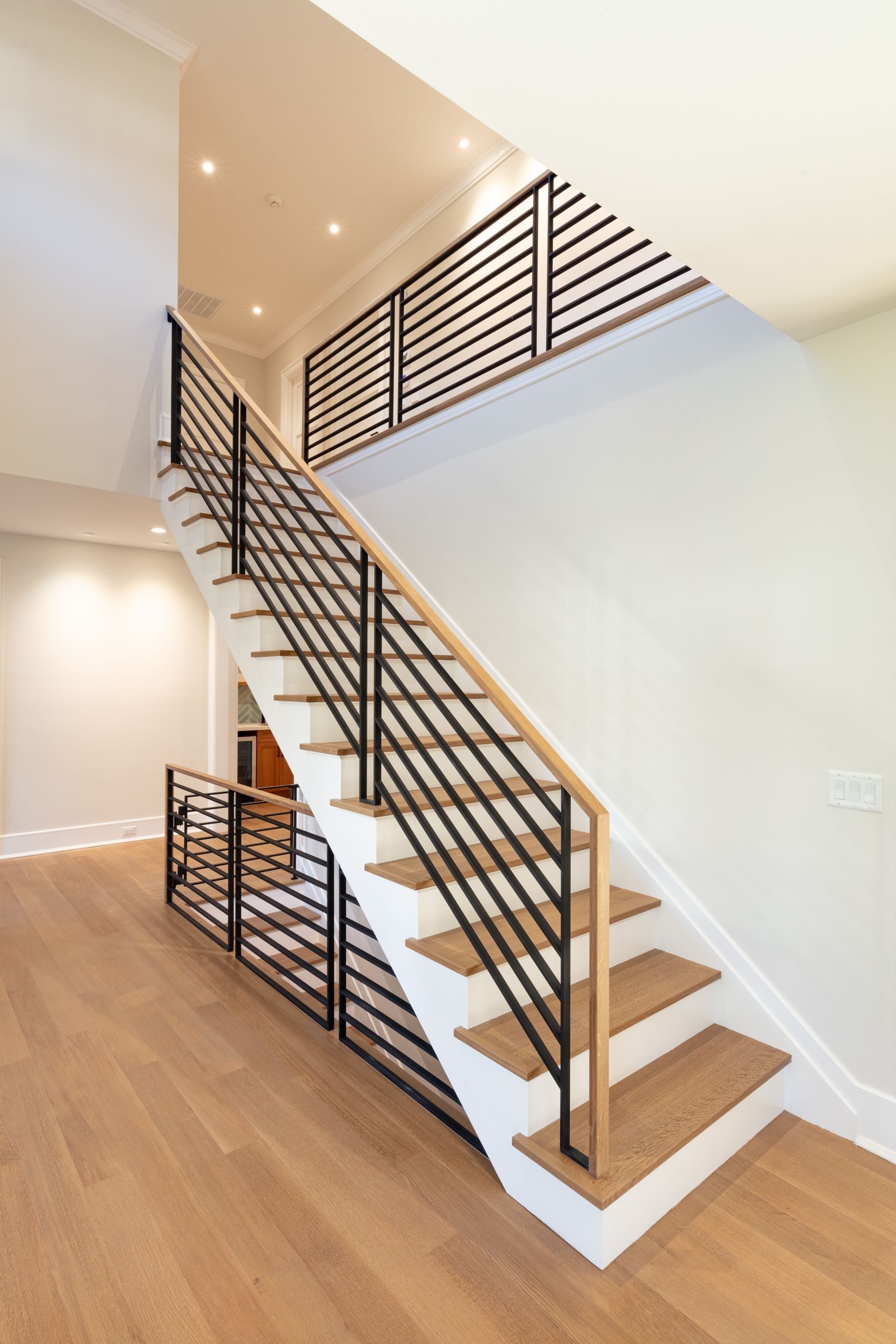 A staircase with wooden steps and a metal railing in a house.