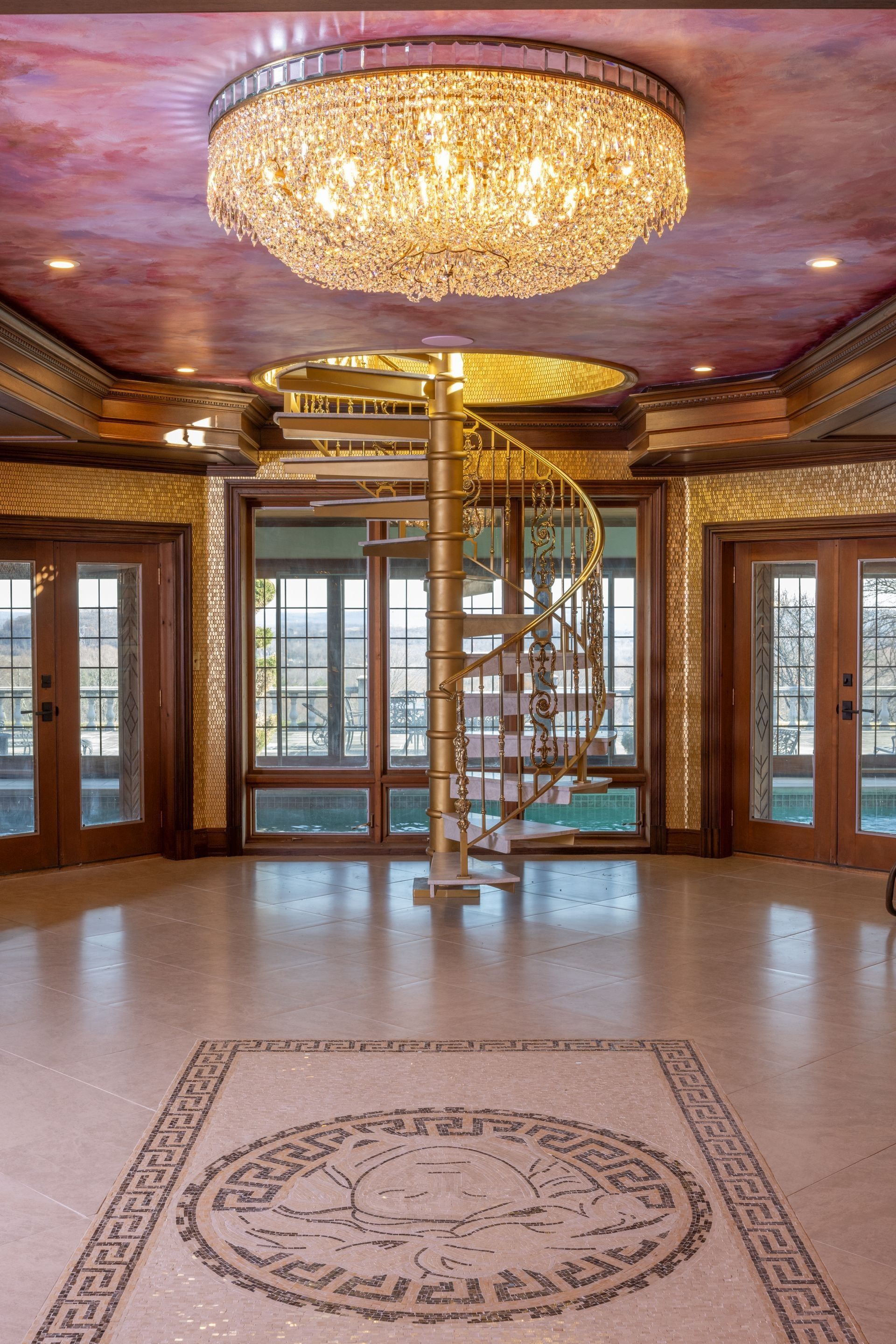 A large room with a spiral staircase and a chandelier.