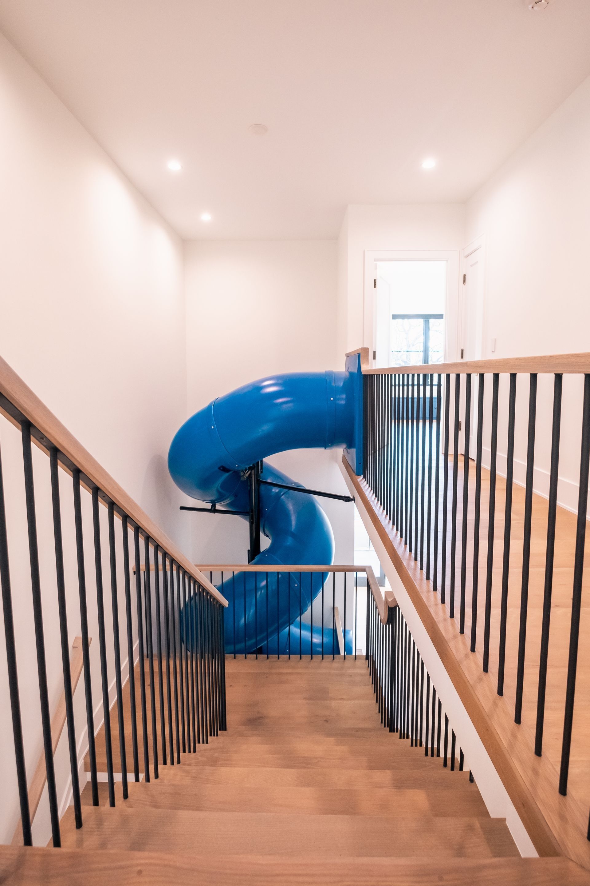 A blue slide is going down a set of stairs.