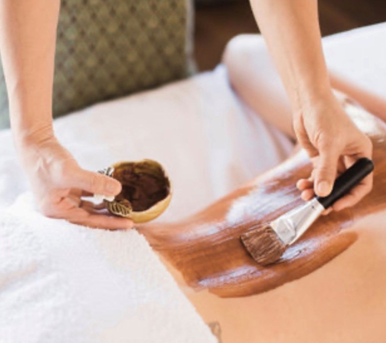 A woman is getting a chocolate treatment on her back