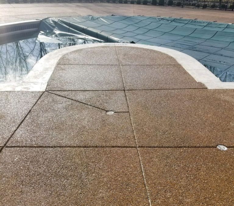Brown rooftop walkway with white edging and a glass roof in the background