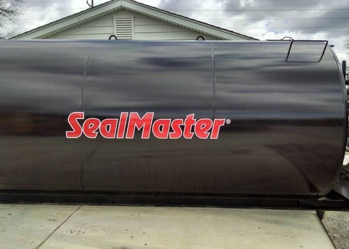 Black SealMaster tank trailer parked outside a building