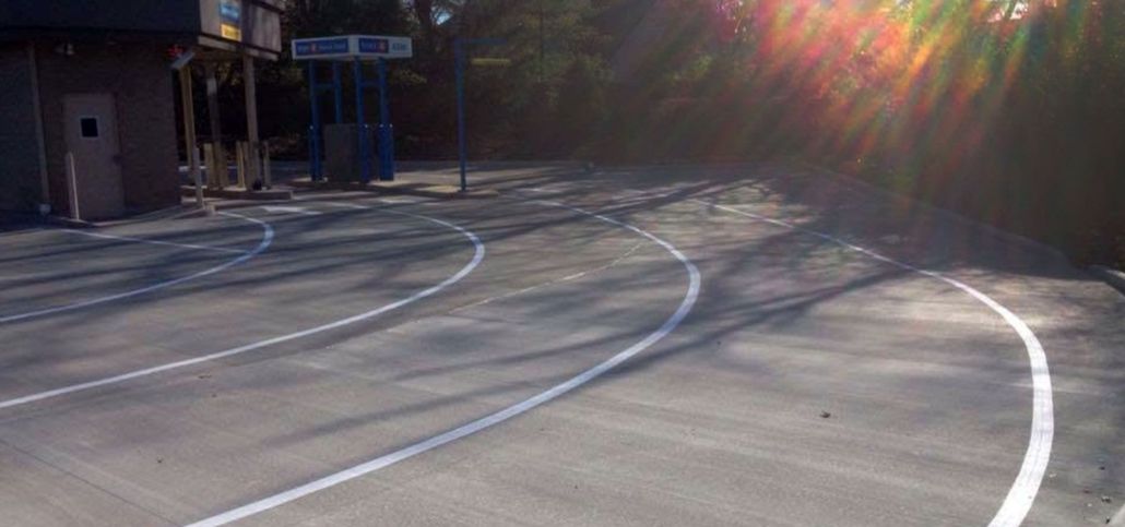 Empty sunlit basketball court with painted lines and long shadows