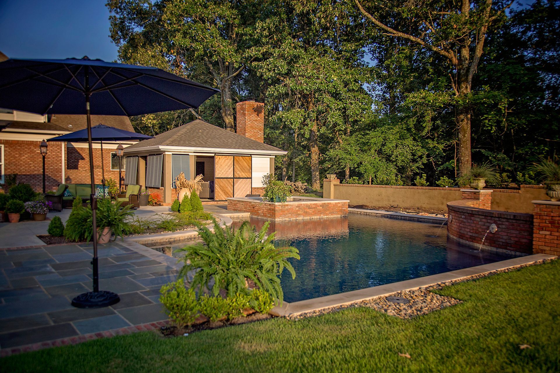 there is a large swimming pool in the backyard of a house .