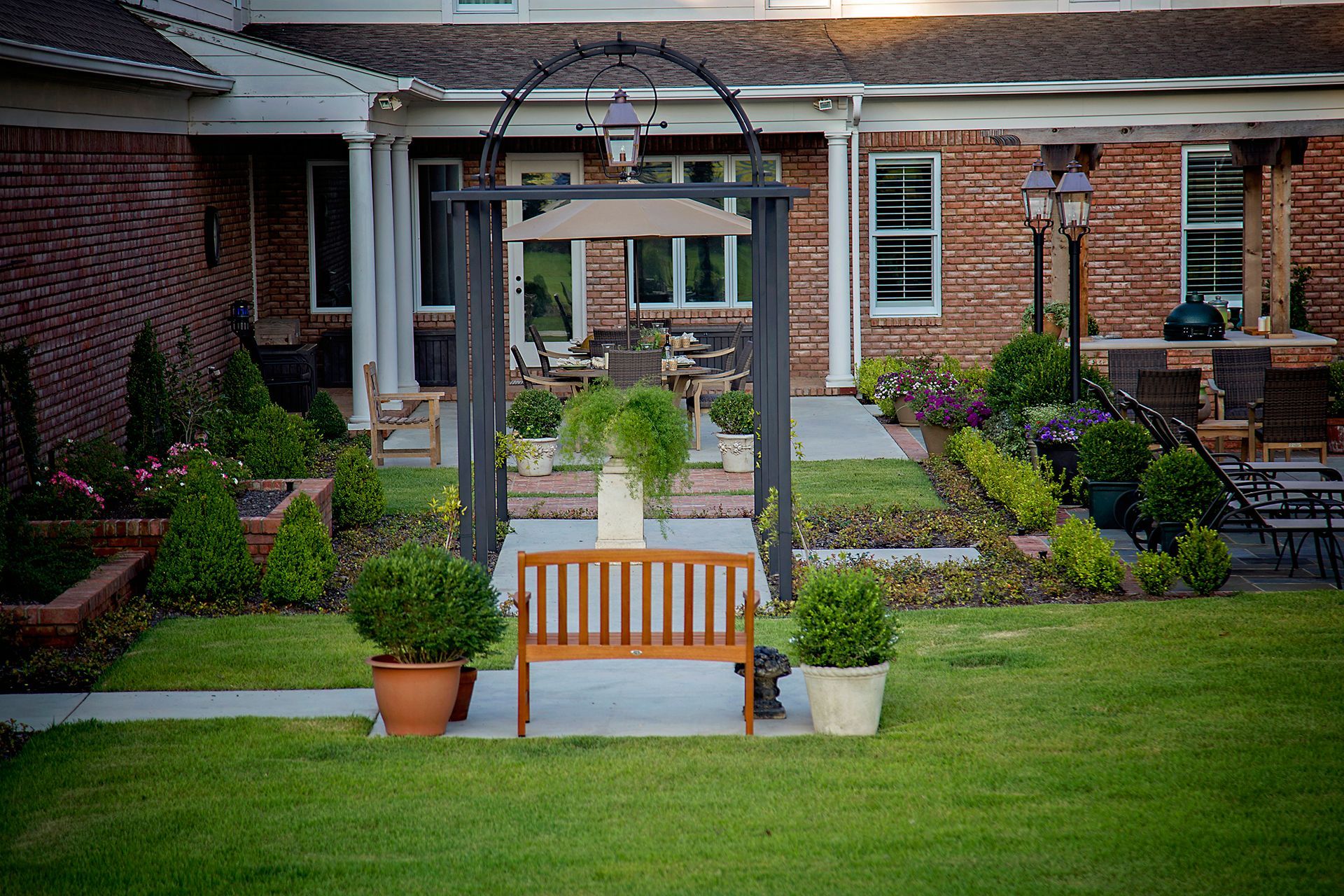 a wooden bench sits in front of a brick house