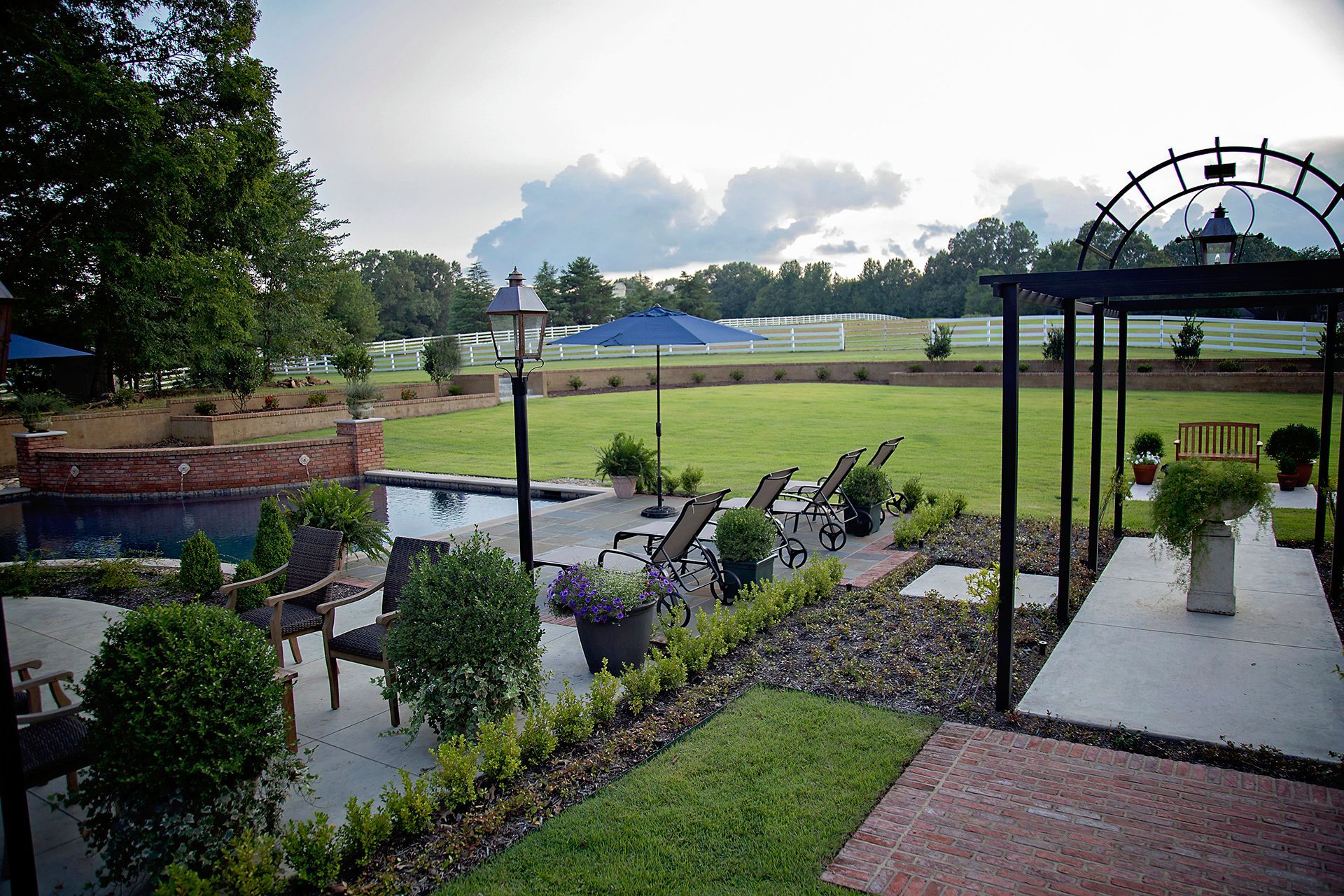 a backyard with a gazebo and chairs and a pool