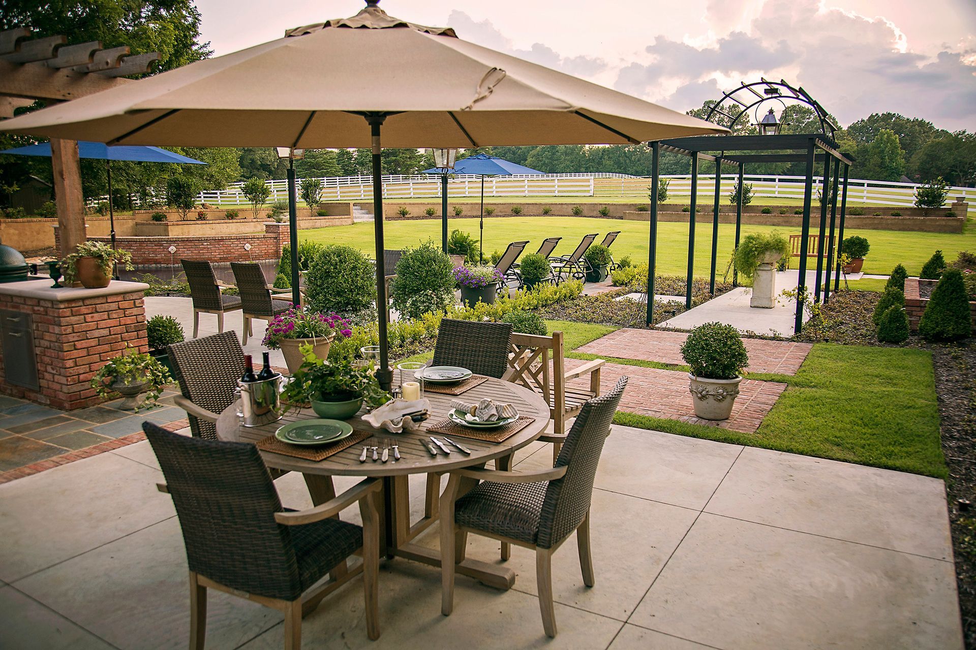 a patio with a table and chairs under an umbrella