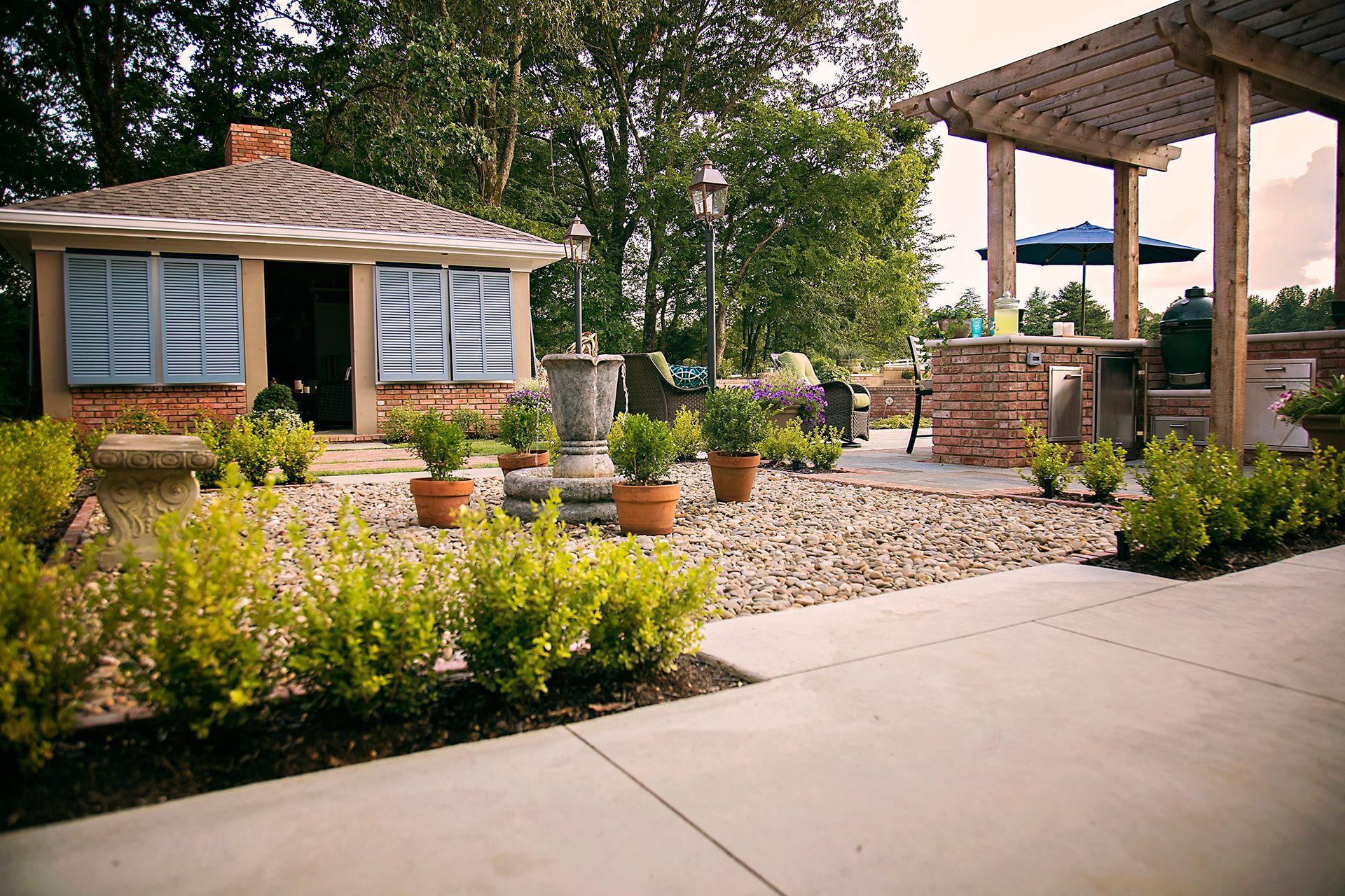 a patio area with a pergola and a house in the background
