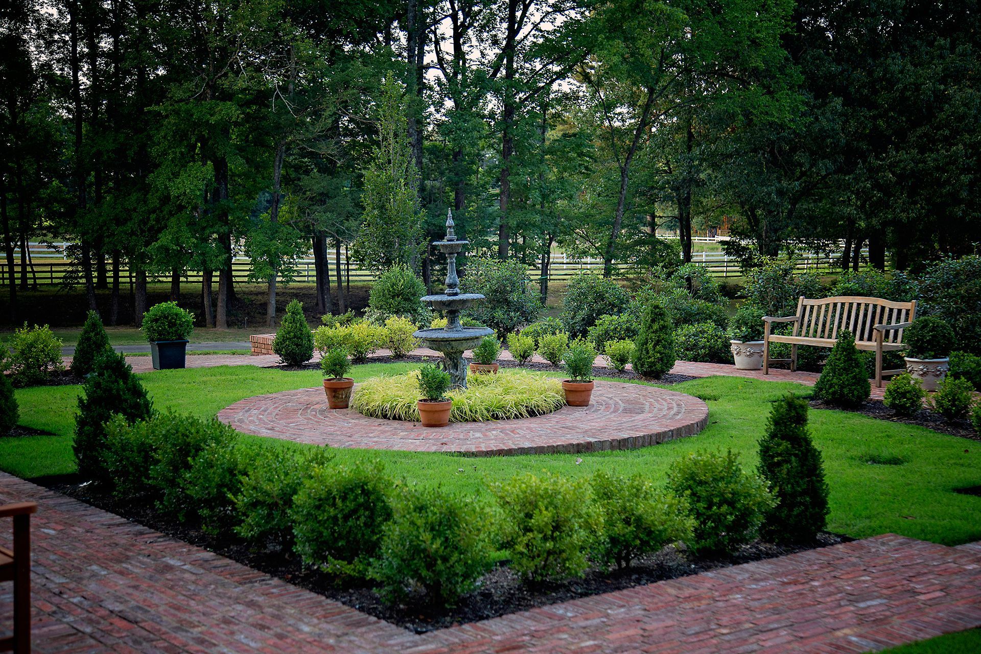 a garden with a fountain in the middle of it