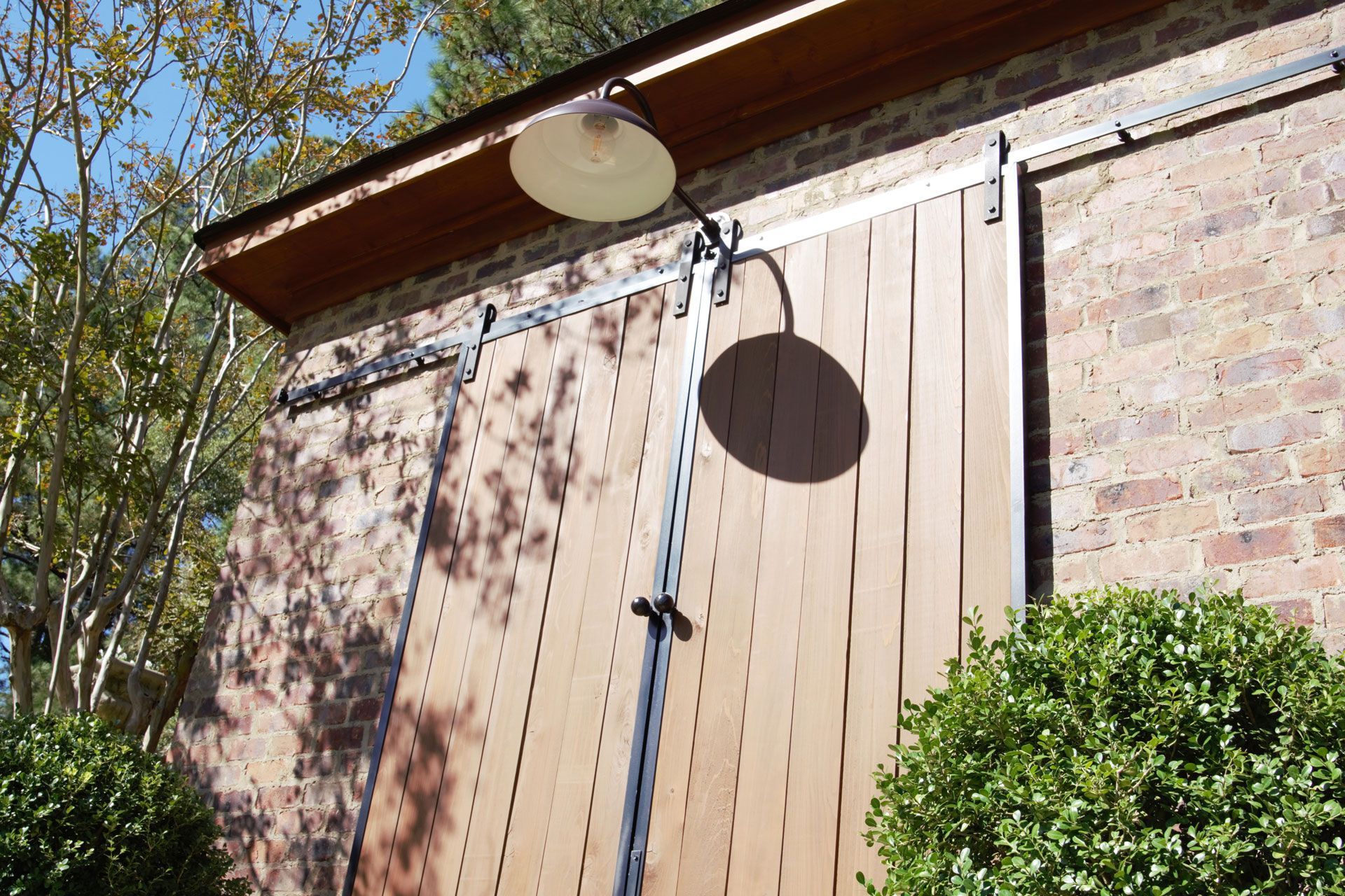 a brick building with a sliding barn door and a light on the roof