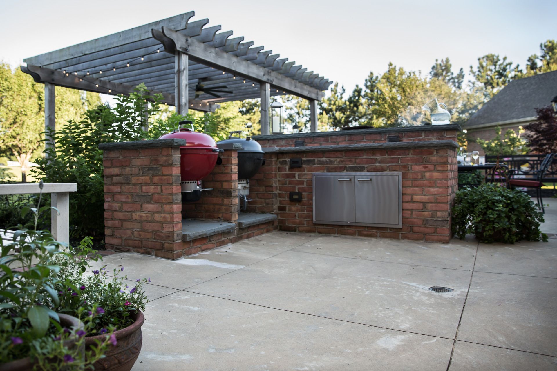 a brick outdoor kitchen with a pergola over it