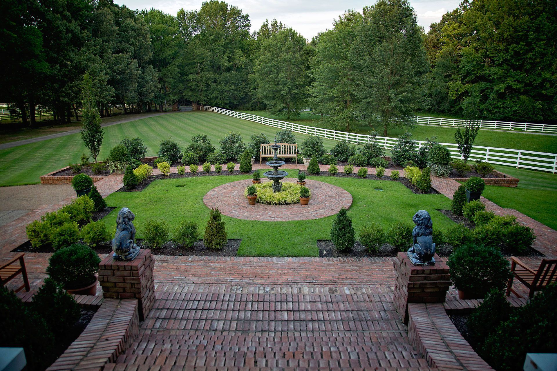 a large lawn with a fountain in the middle of it