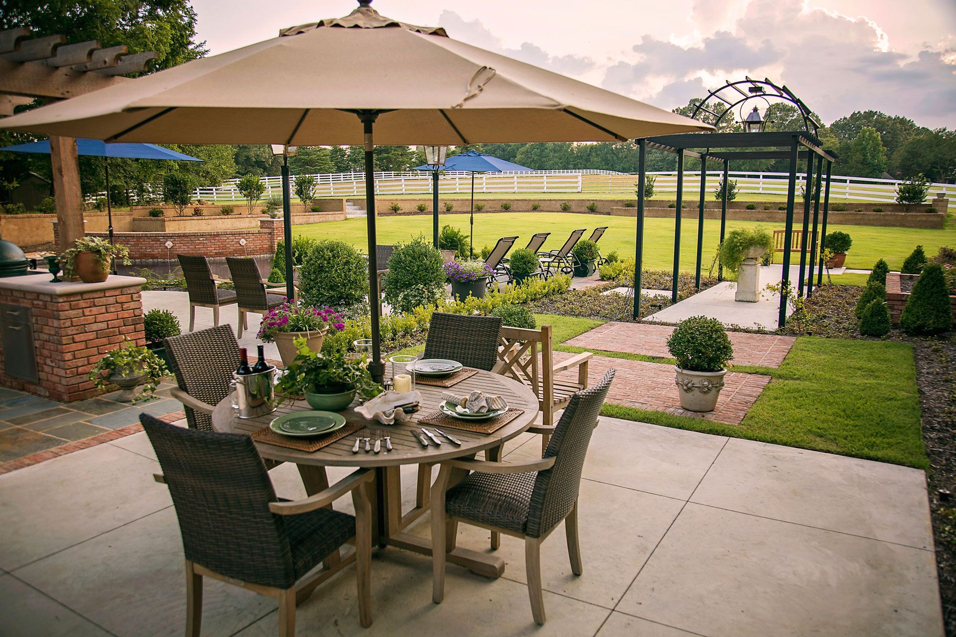 a patio with a table and chairs under an umbrella