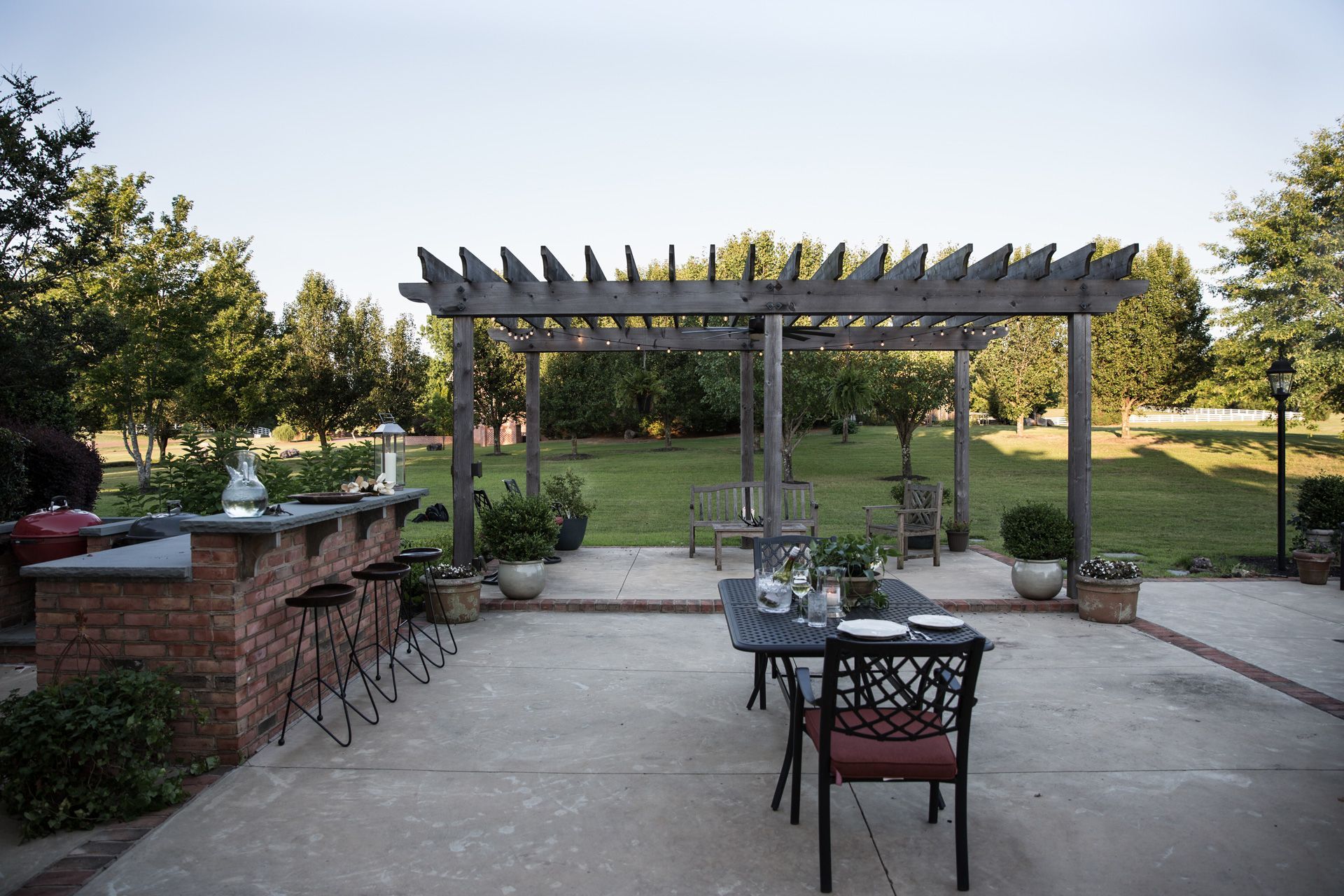 a patio with a table and chairs in front of a pergola