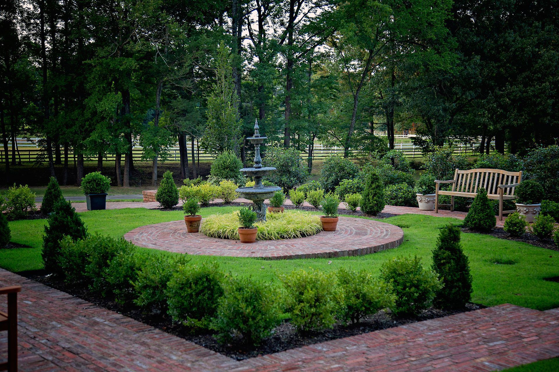 a garden with a fountain in the middle of it