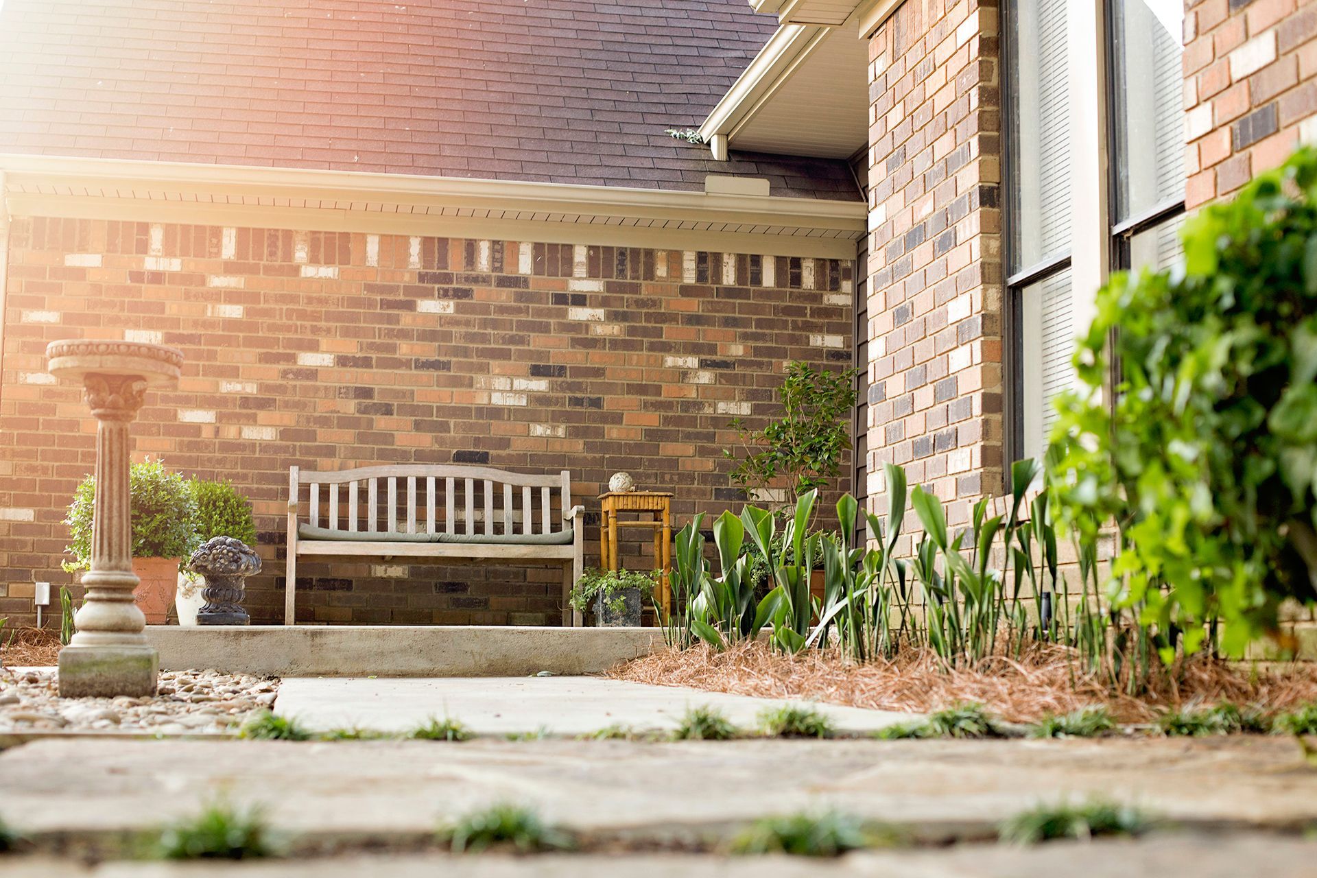a brick house with a bench in front of it .