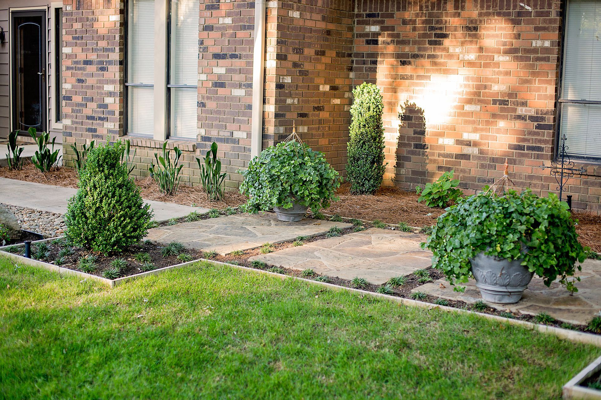 a brick house with a lush green lawn in front of it