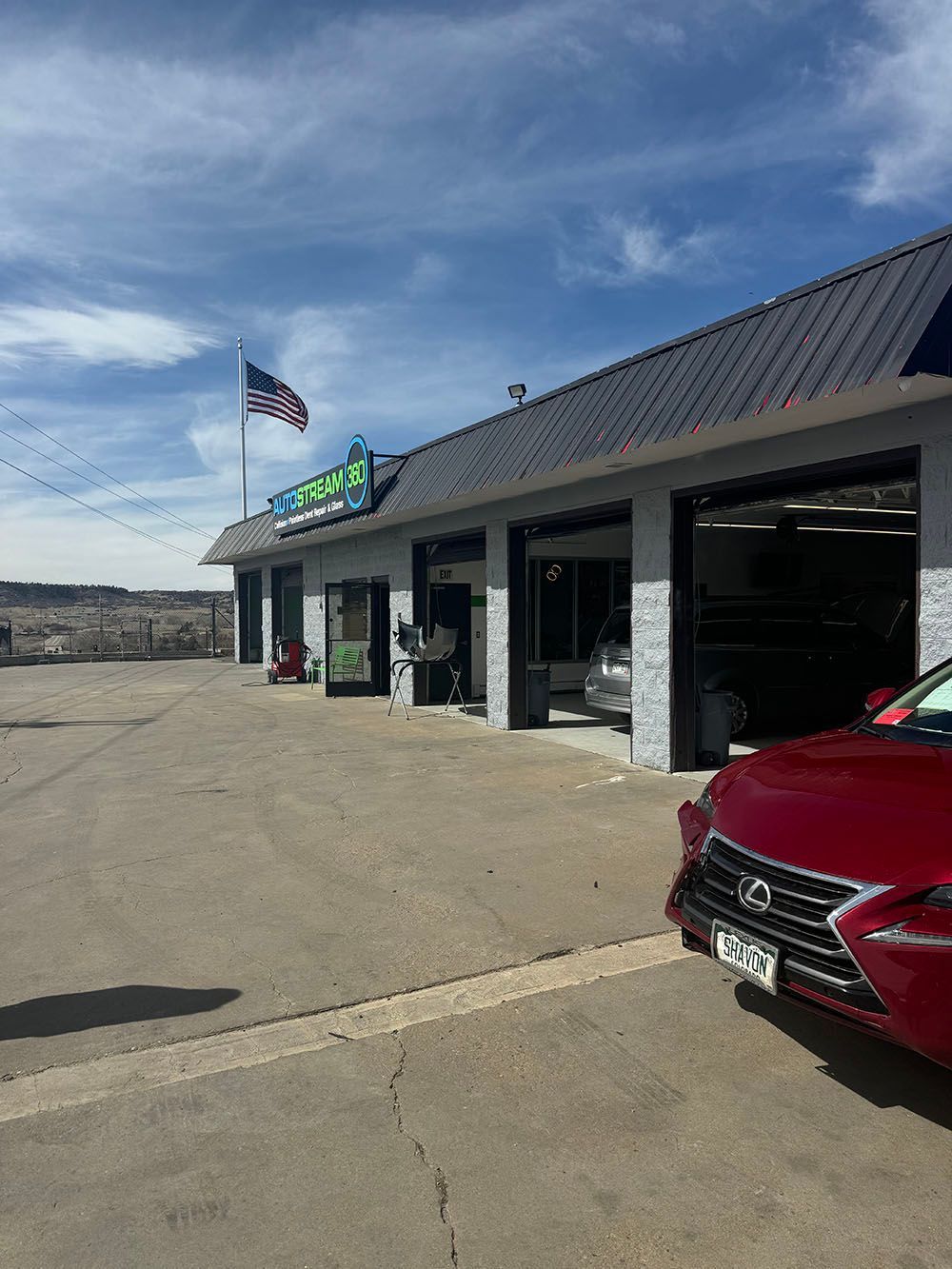 A red car is parked in front of a car wash.