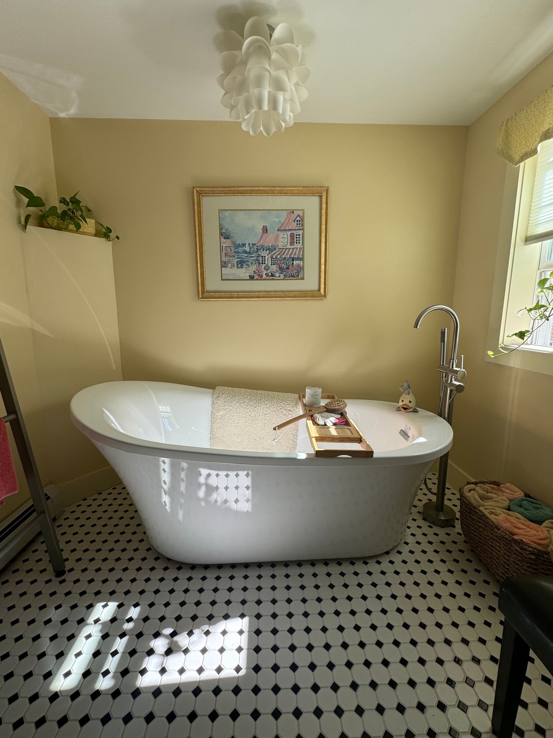 A bathtub in a bathroom with a picture on the wall
