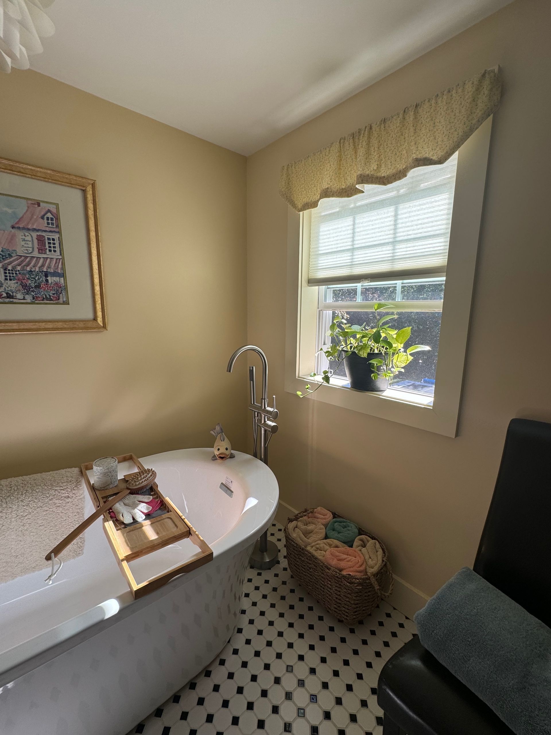 A bathtub in a bathroom next to a window