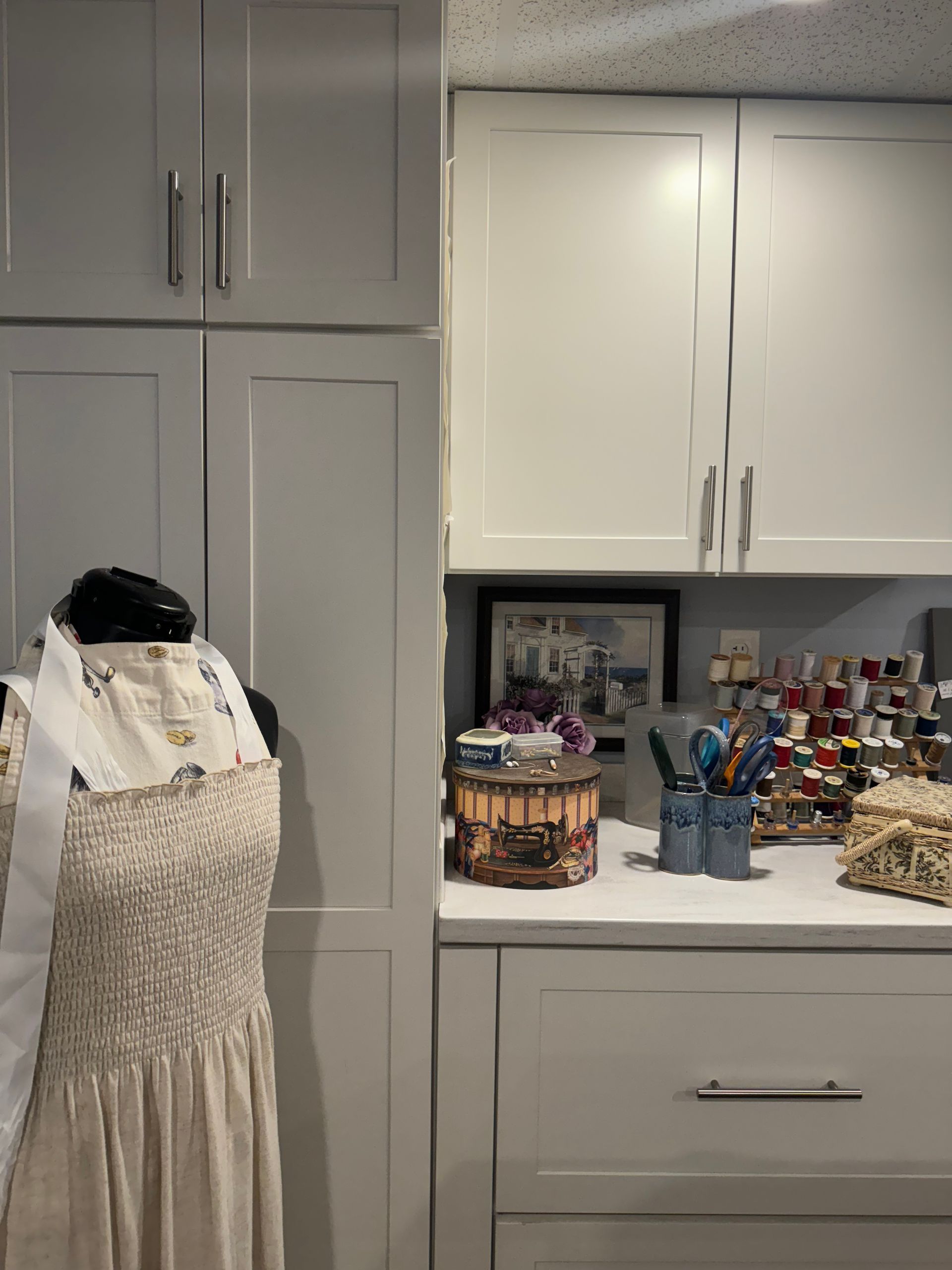 A white dress is on a mannequin in a room with white cabinets