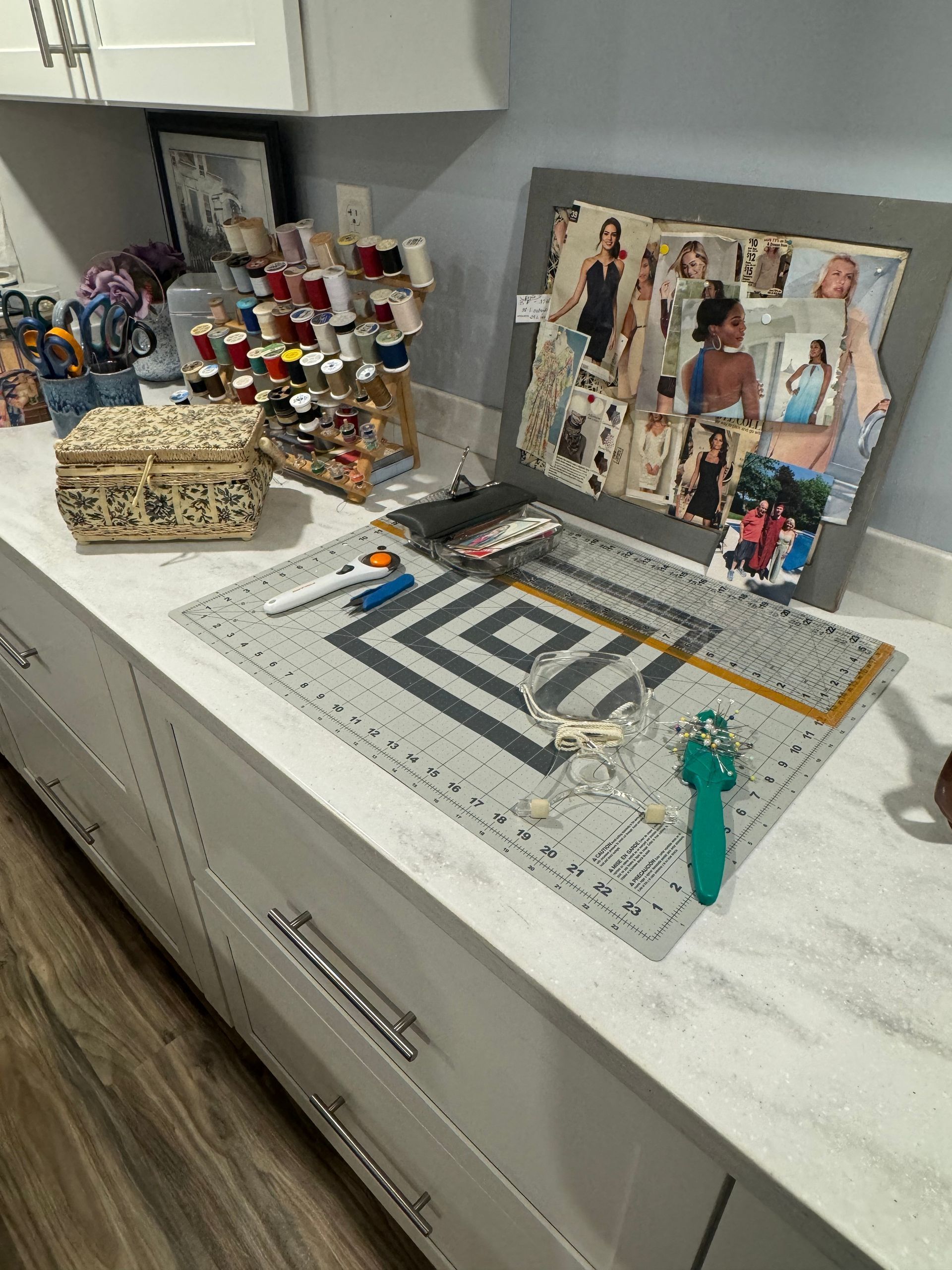 A counter top with a cutting mat and various sewing materials