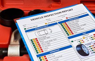 A vehicle inspection report is sitting on top of a toolbox.