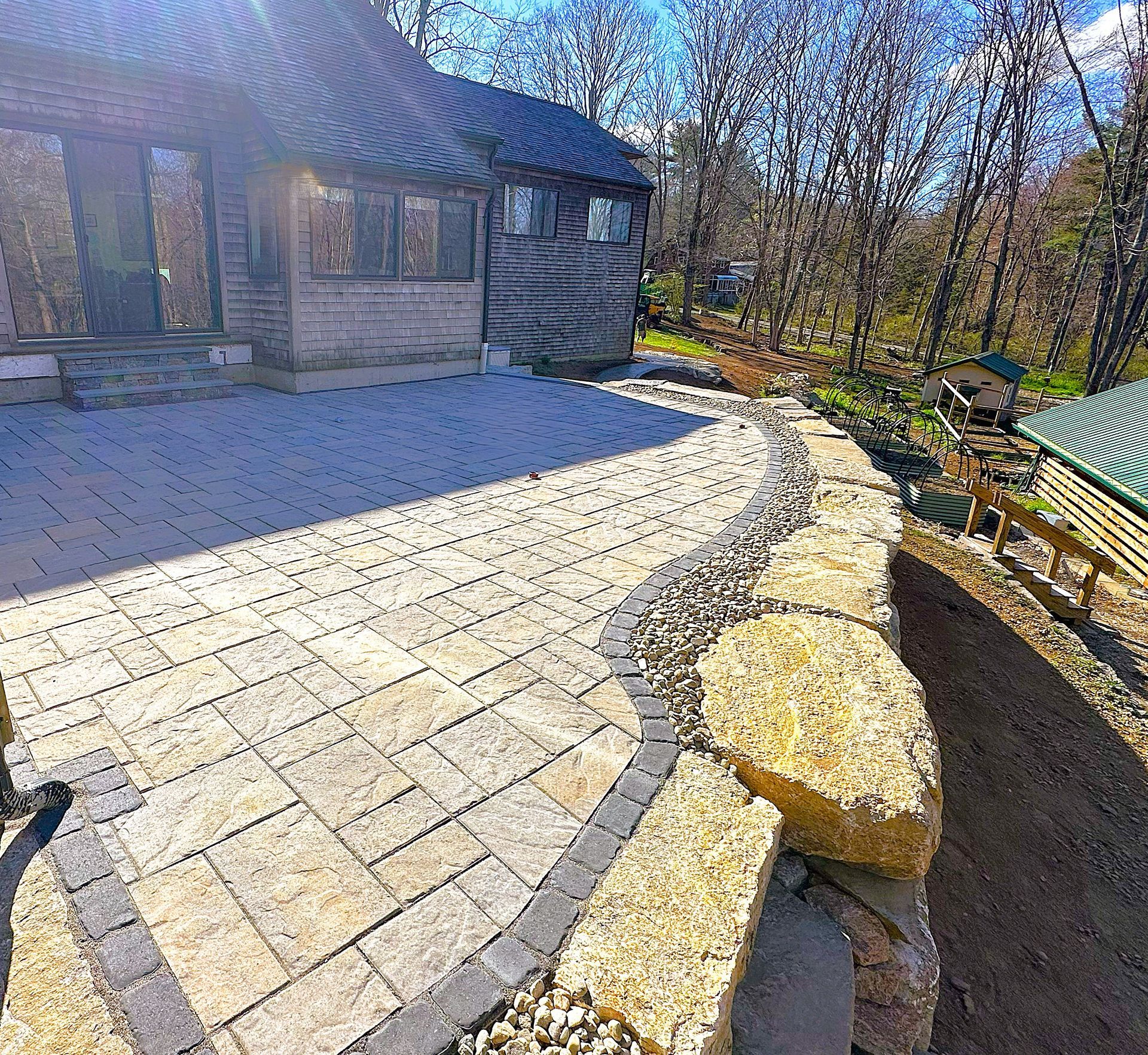 A brick walkway leading to a house in the woods.