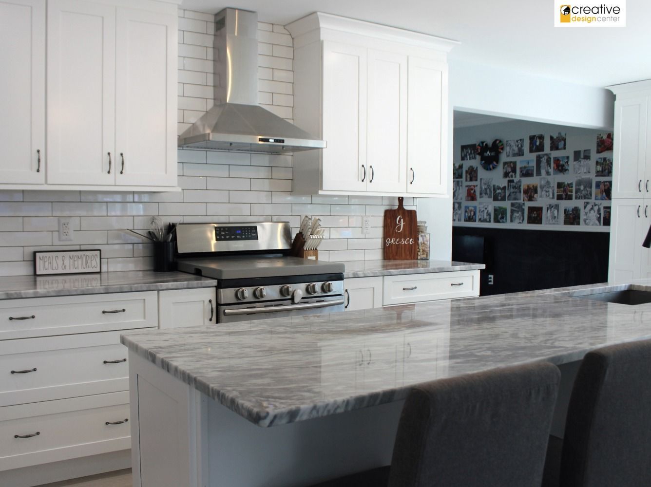 A kitchen with white cabinets and granite counter tops.