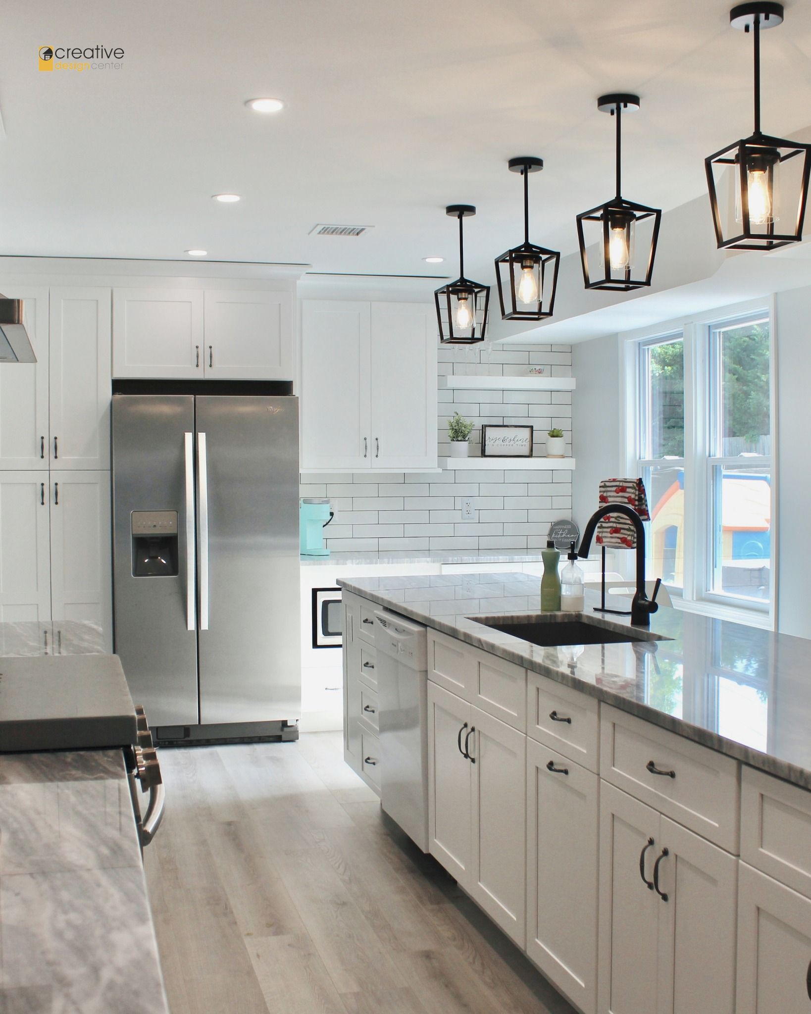 A kitchen with stainless steel appliances and white cabinets.