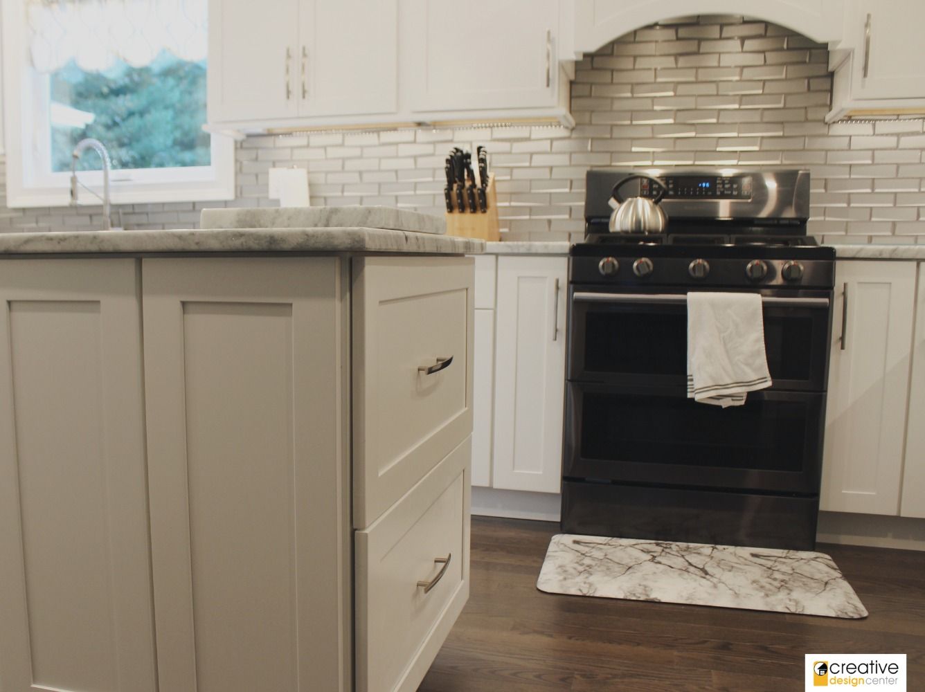 A kitchen with white cabinets and a black stove.