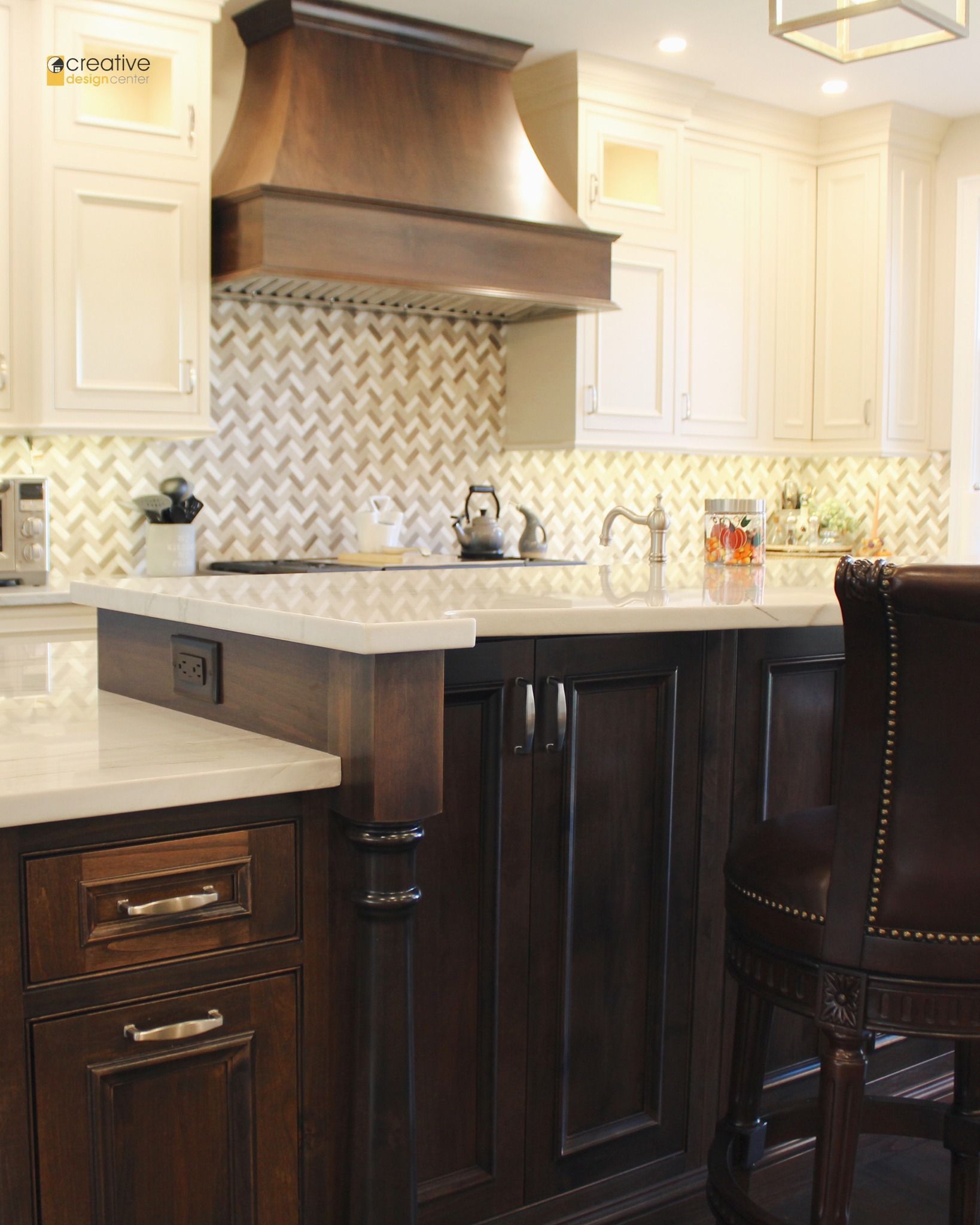 A kitchen with a copper hood and white cabinets.